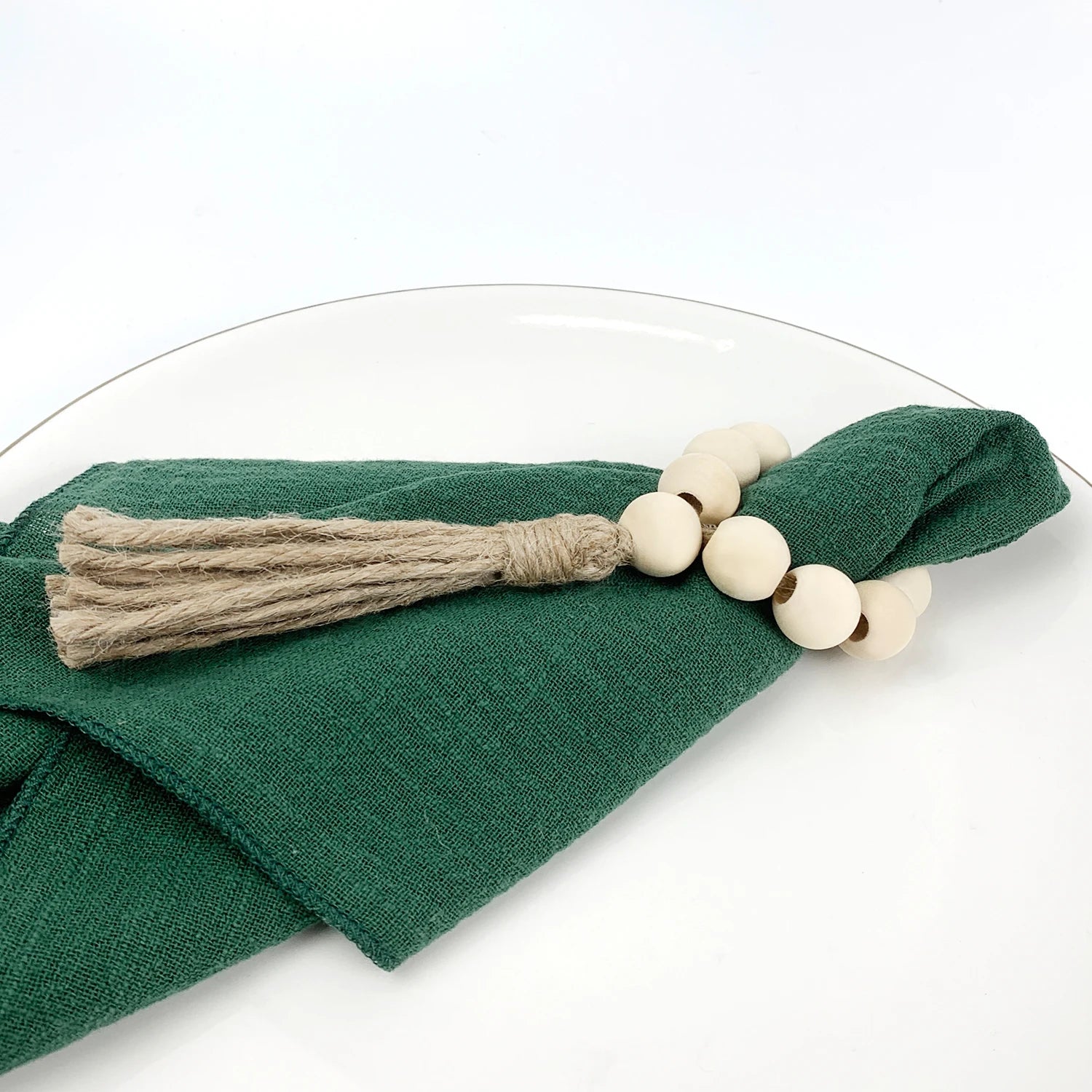 Serviette verte en coton avec perles en bois et franges en jute.