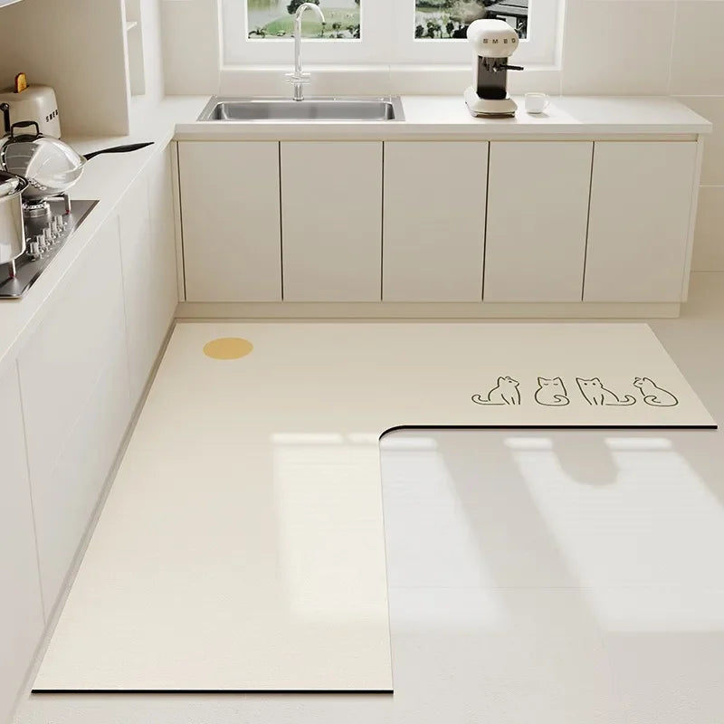 Une salle de cuisine moderne et élégante avec un évier en acier inoxydable, des rangements blancs et un tapis de sol motif chats.