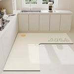 Une salle de cuisine moderne et élégante avec un évier en acier inoxydable, des rangements blancs et un tapis de sol motif chats.