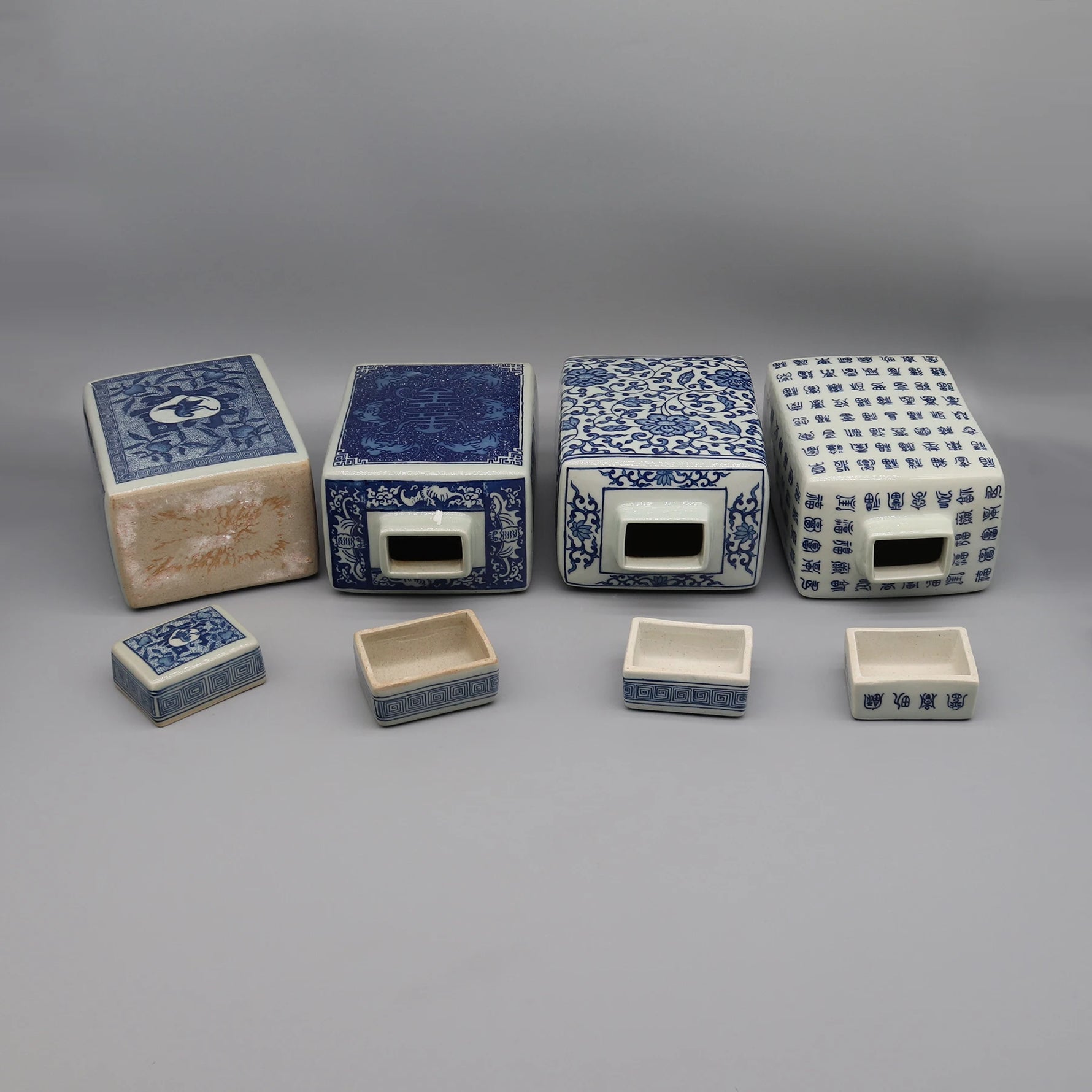 Une collection de boîtes décoratives en céramique bleu et blanc avec des motifs et des inscriptions orientaux.