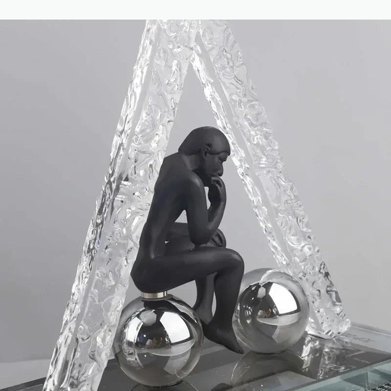 sculptures décoratives modernes homme assis sphères figures suspendues transparentes textures cristallines contemporaines