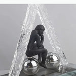 sculptures décoratives modernes homme assis sphères figures suspendues transparentes textures cristallines contemporaines