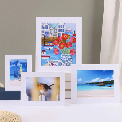 Cadre photo blanc minimaliste en papier posé sur une table