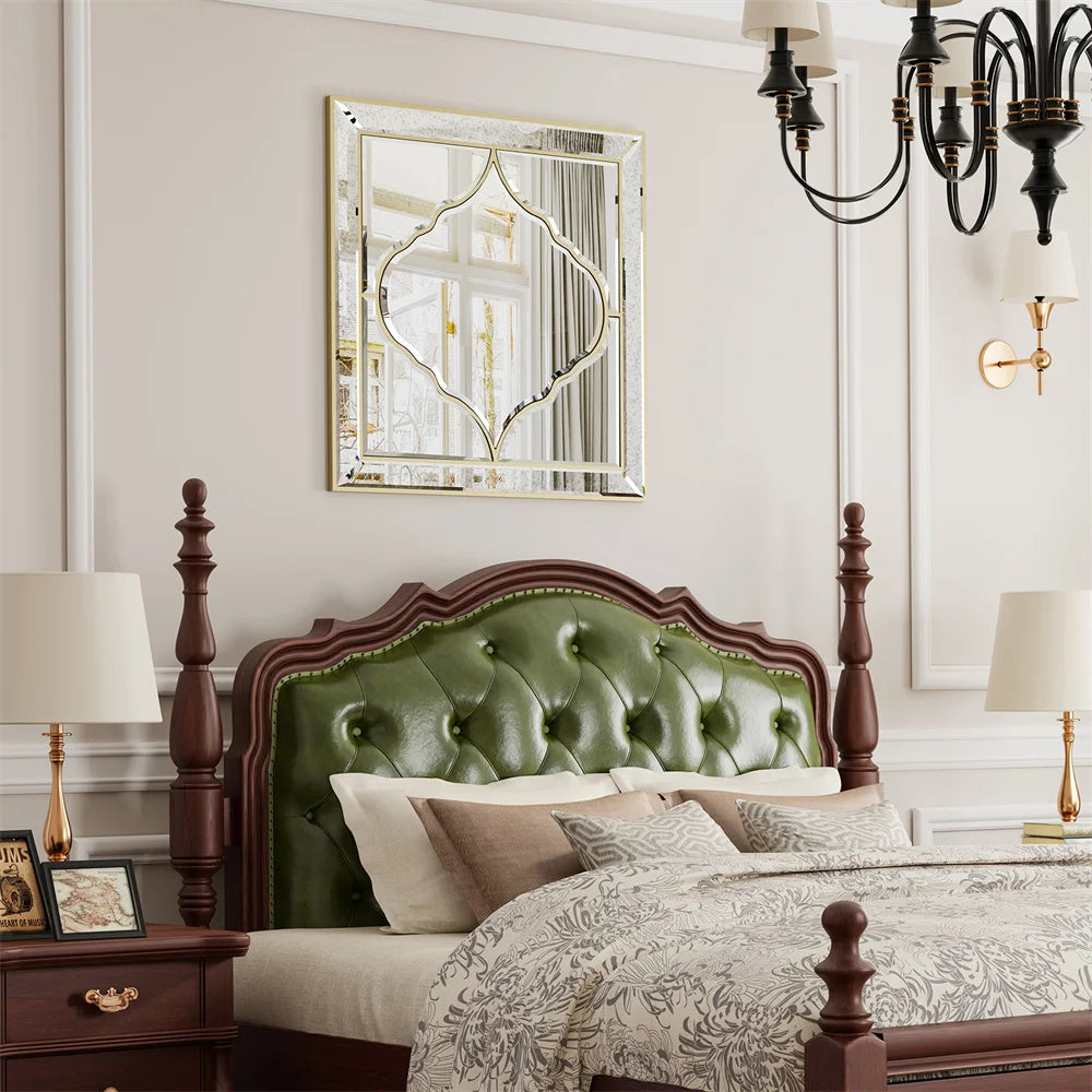 Une chambre à coucher élégante avec un lit à baldaquin en bois sombre, une tête de lit capitonnée verte, des lampes de chevet, un miroir décoratif et un lustre noir.
