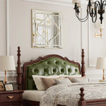 Une chambre à coucher élégante avec un lit à baldaquin en bois sombre, une tête de lit capitonnée verte, des lampes de chevet, un miroir décoratif et un lustre noir.