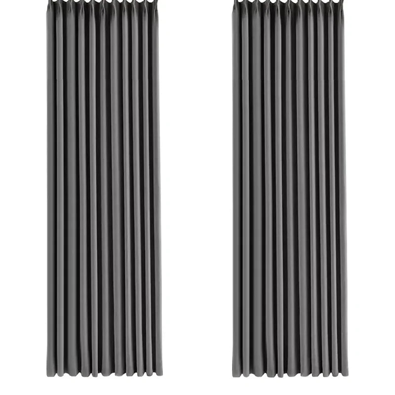 Deux panneaux de rideaux gris en velours suspendus, vus de face, bien plissés et allongés, illustrant la longueur et la régularité des plis.