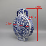 Cette amphore en céramique bleu et blanc est ornée de motifs floraux complexes, représentant des pivoines et autres fleurs stylisées.