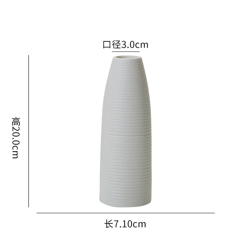 Vase céramique de couleur blanche, avec un design à texture striée, mesurant 20,1 cm de hauteur et 7,1 cm de diamètre à l'ouverture.