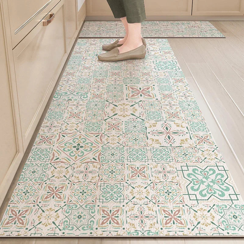 Tapis de sol décoratif avec un motif géométrique multicouche dans des nuances de vert et beige, sur lequel reposent des pieds chaussés de ballerines.