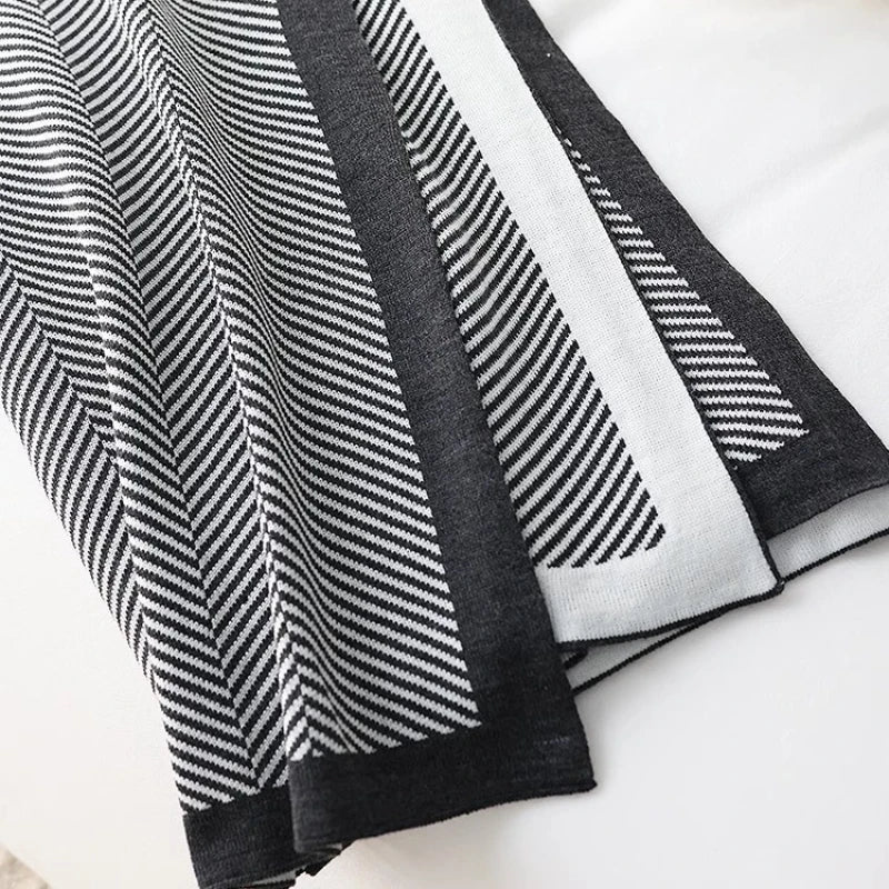 Cette image montre des tissus noirs et blancs avec des motifs rayés et en zigzag, créant un effet visuel dynamique et contrasté.