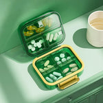 boîte rangement médicaments réutilisable transparente moderne vert bleu violet poignée dorée compartments