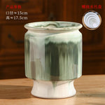 Un bol de céramique décoratif de couleur vert pâle, avec un motif marbré, reposant sur un support.