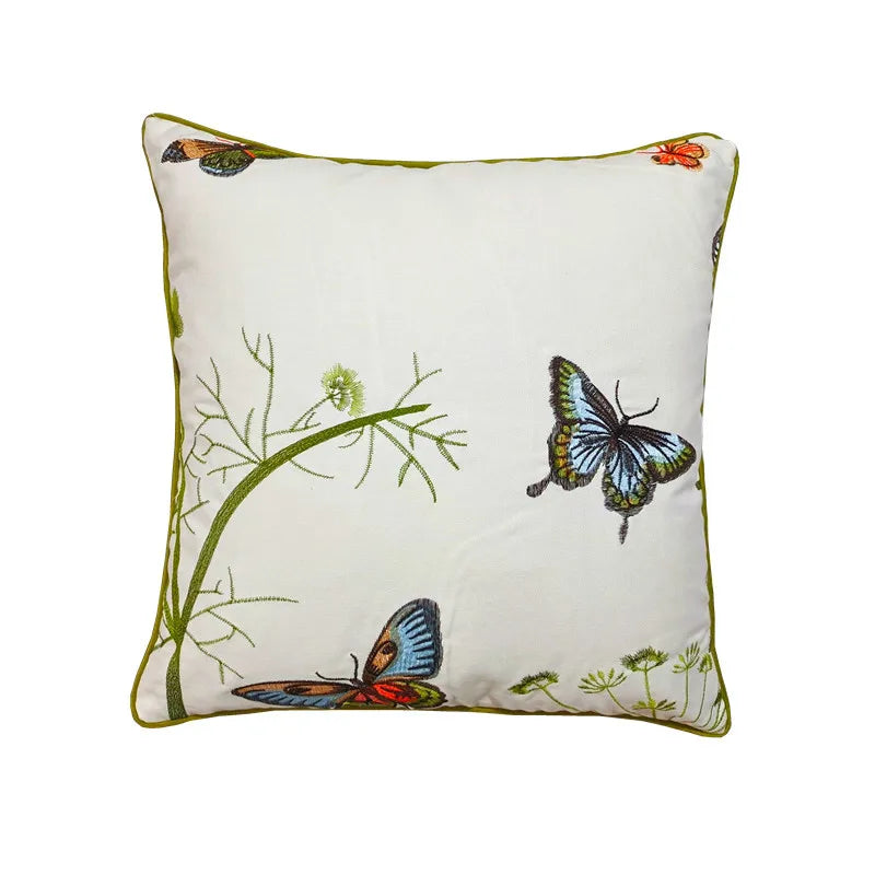 Ce coussin décoratif présente un motif floral et des papillons multicolores, créant une atmosphère naturelle et apaisante.