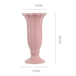 Vase en céramique de couleur rose pâle avec un design élégant en forme de tulipe.