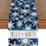 Image de fond de table représentant une décoration d'hiver avec un motif de flocons de neige blancs sur un fond bleu foncé et le texte "Hello Winter" au centre.