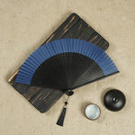 éventail traditionnel bleu noir beige rayures horizontales perforations classique artisanal cordelette pompon