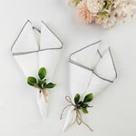 Serviettes de table blanches décorées de feuilles de verdure, liées avec de la ficelle de jute, entourées d'un bouquet de fleurs roses délicates sur fond blanc.