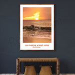 Une personne surfe sur une vague au coucher de soleil sur la plage de Port Louis en Guadeloupe.