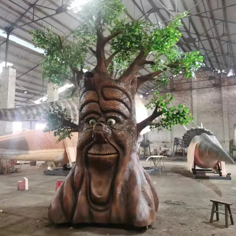 sculpture arbre anthropomorphique feuilles colorées marron vert orange texture bois yeux jaunes sourire