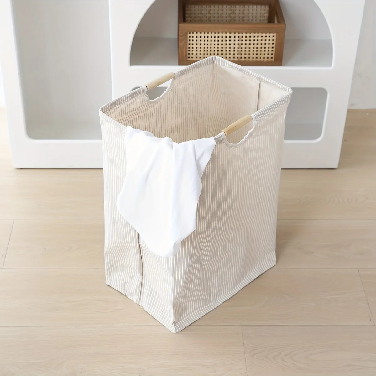 Panier à linge autoportant placé dans une chambre à coucher élégante