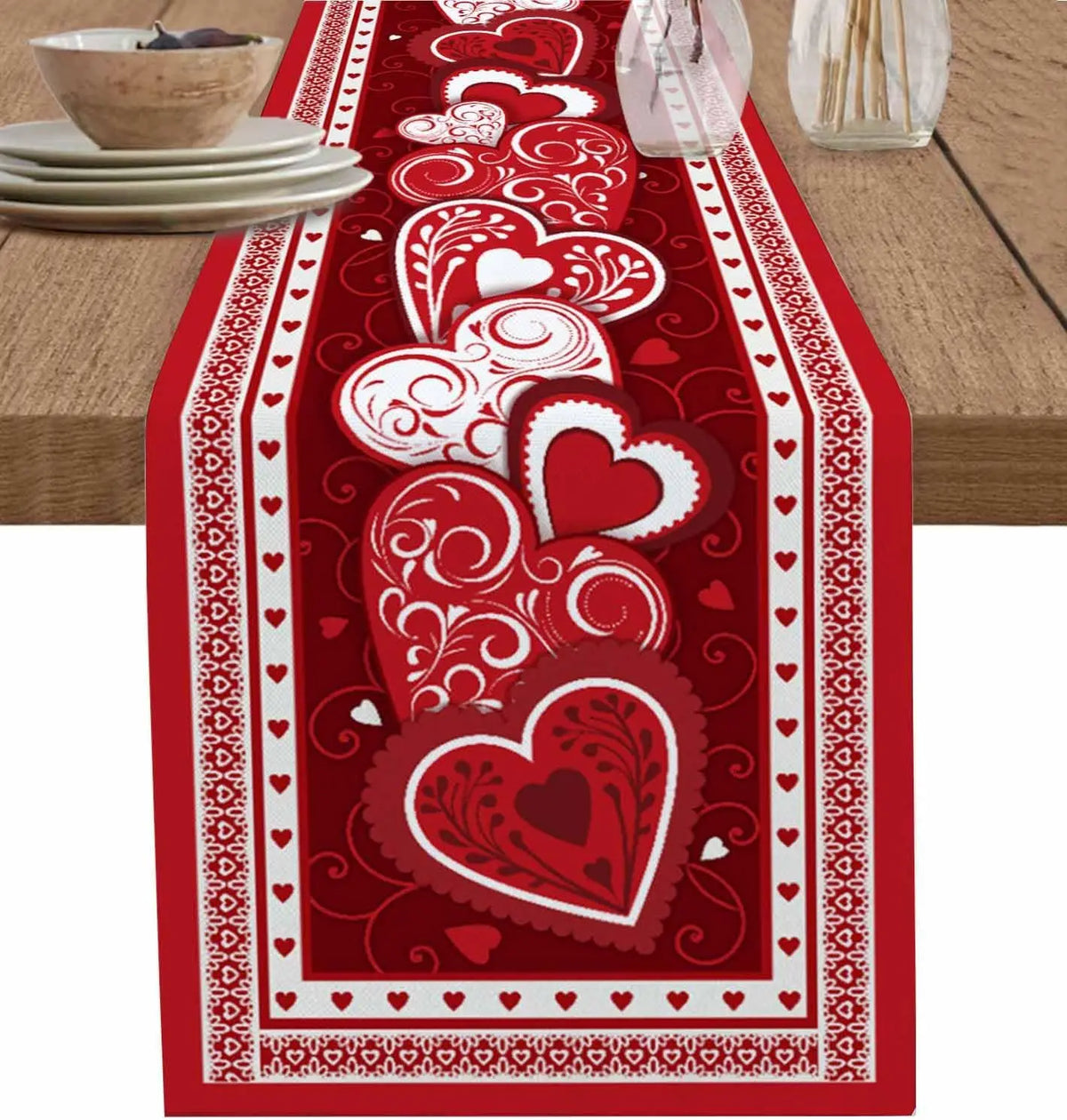 Chemin de table décoré de motifs rouges et blancs en forme de cœurs, créant une ambiance romantique pour une célébration.