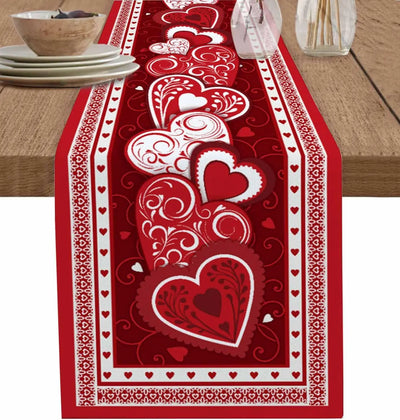 Chemin de table décoré de motifs rouges et blancs en forme de cœurs, créant une ambiance romantique pour une célébration.
