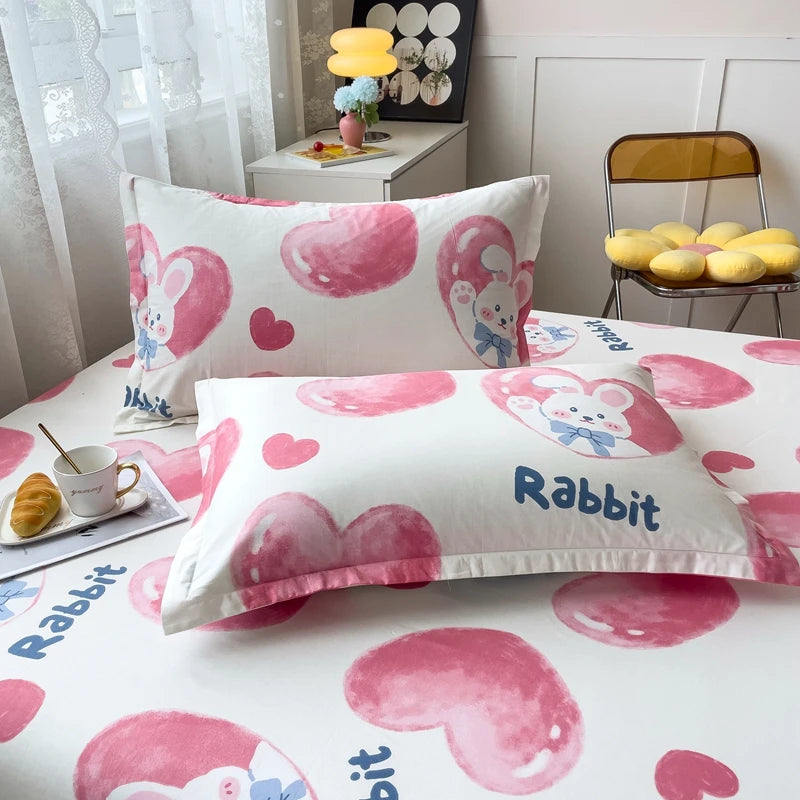 Linge de lit coloré avec des motifs de lapins roses sur fond blanc, parfait pour une chambre d'enfant.