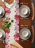 Une table dressée avec de la vaisselle et des couverts sur un joli motif de cœurs et de pois, avec un plat de pain et une plante verte.