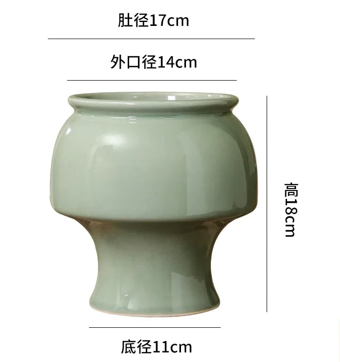 Vase de style oriental en céramique vert clair, avec une forme évasée et un pied élégant.