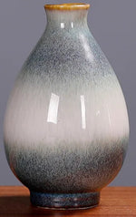 Vase décoratif en céramique de style japonais avec une finition dégradée de couleurs gris et orange, de forme élancée et mesurant environ 9,5 cm de hauteur.