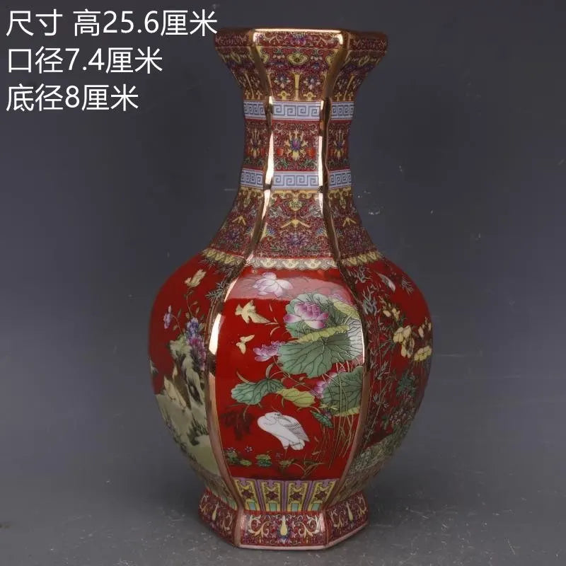 Un vase en porcelaine peint à la main avec des motifs floraux élégants sur un fond rouge vif, accompagné de mesures détaillées.