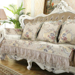 Un canapé baroque élégant orné de coussins floraux et de détails ouvragés, dans un style richement décoré.