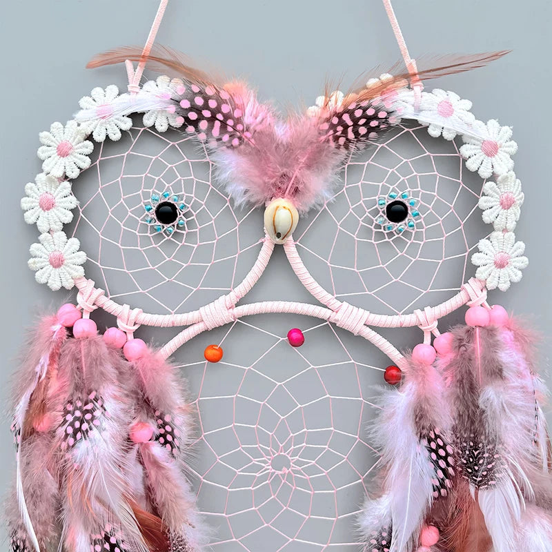 Un magnifique rêve attracteur rose et blanc, orné de plumes colorées et de perles brillantes, qui apporte une touche de magie et de mystère.