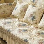Un canapé orné de motifs floraux délicats et de bordures dorées, créant une atmosphère élégante et luxueuse.