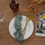 serviette table carrée orange franges moderne élégante fourchettes cuillères assiettesbranches séchées guirlande bougie parfumée