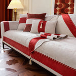 Un canapé élégant avec des éléments décoratifs rouges et gris, créant une ambiance chaleureuse et sophistiquée.