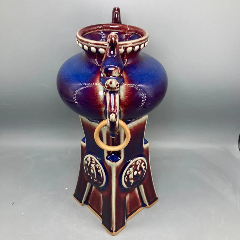 Un superbe vase décoratif en céramique de couleurs chaudes et profondes, avec des motifs et des ornements élégants, créant une pièce unique et artistique.