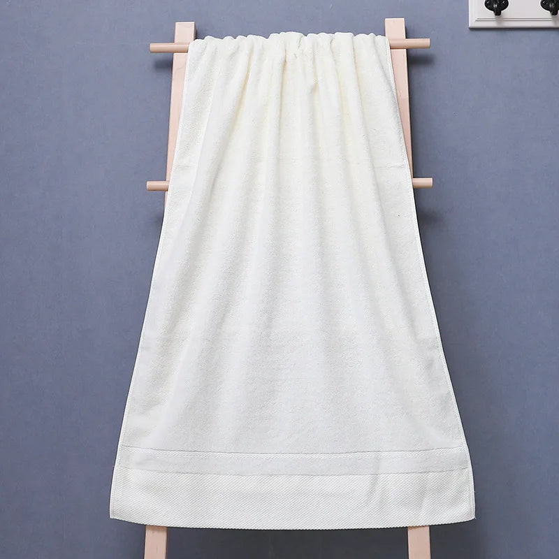 Une serviette de bain blanche suspendue sur un porte-serviette en bois.