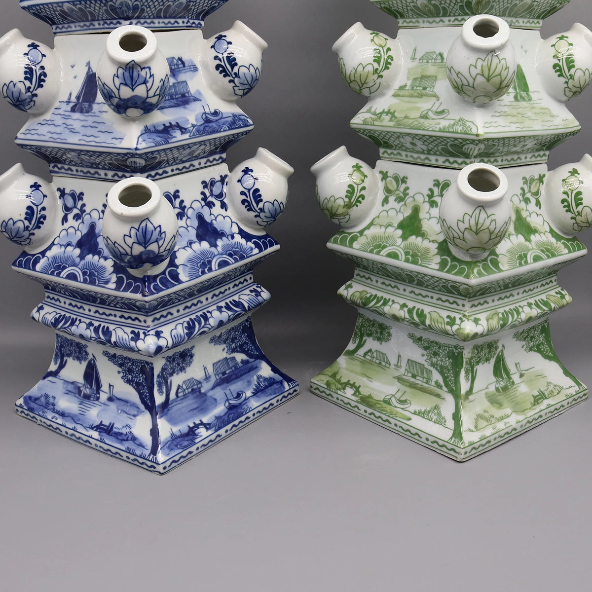 Deux belles boîtes décoratives en porcelaine, l'une dans des tons bleus et blancs avec des motifs de voiliers, l'autre dans des couleurs vertes et blanches avec des motifs floraux.