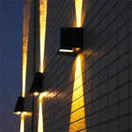 Lampe solaire murale allumée la nuit dans un jardin
