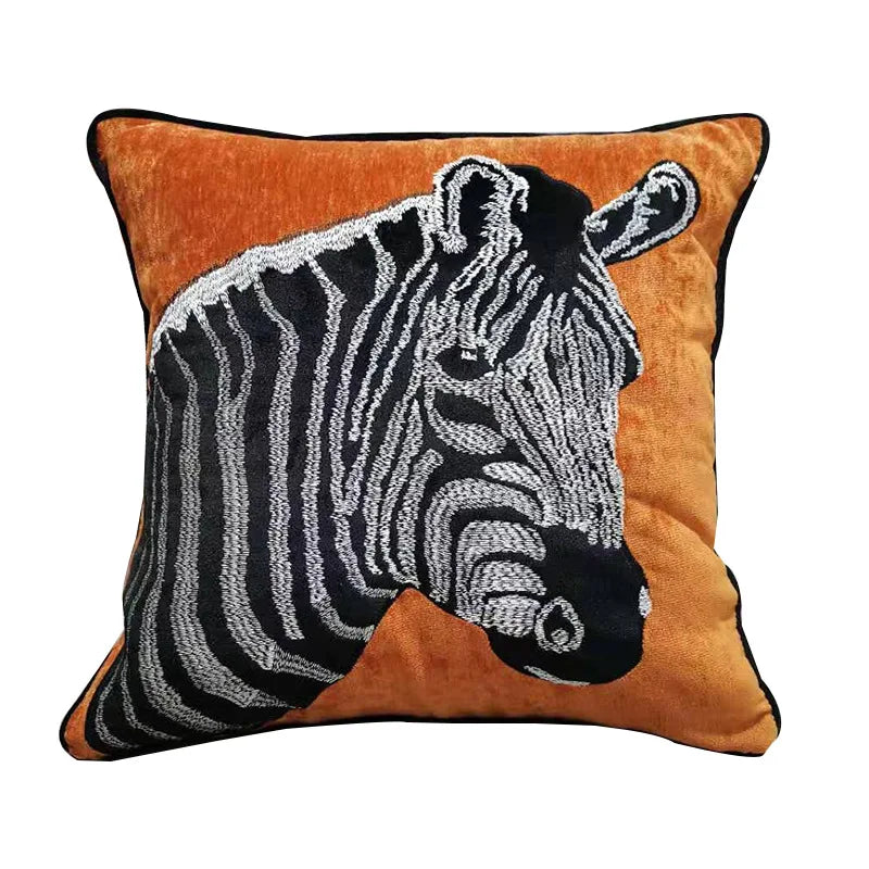 Un coussin décoratif orné d'un motif de zèbre, avec un fond orange et des rayures noires et blanches.
