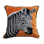 Un coussin décoratif orné d'un motif de zèbre, avec un fond orange et des rayures noires et blanches.