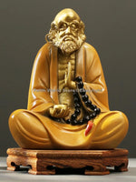 statue homme assis jaune doré rouge art bouddhiste traditionnel noires base bois sombre