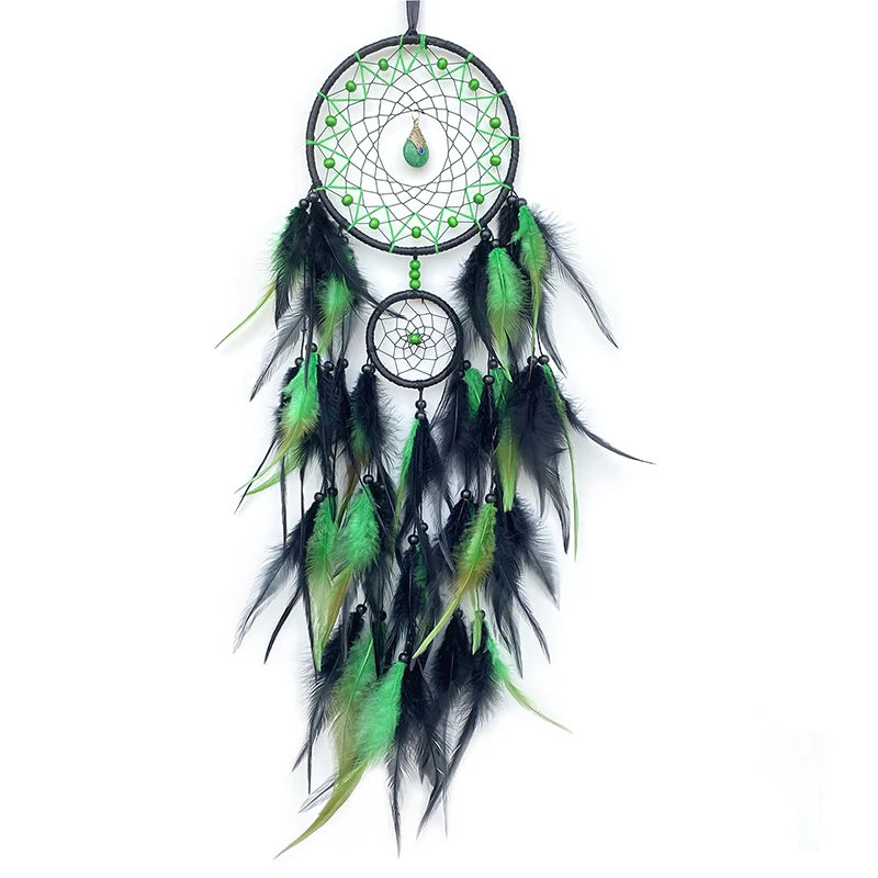 Capteur de rêves vert et noir orné de plumes colorées et d'un pendentif en forme de goutte suspendu au centre.