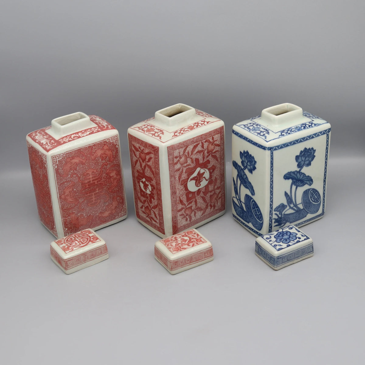 Trois vases en céramique de style asiatique avec des motifs floraux et géométriques.