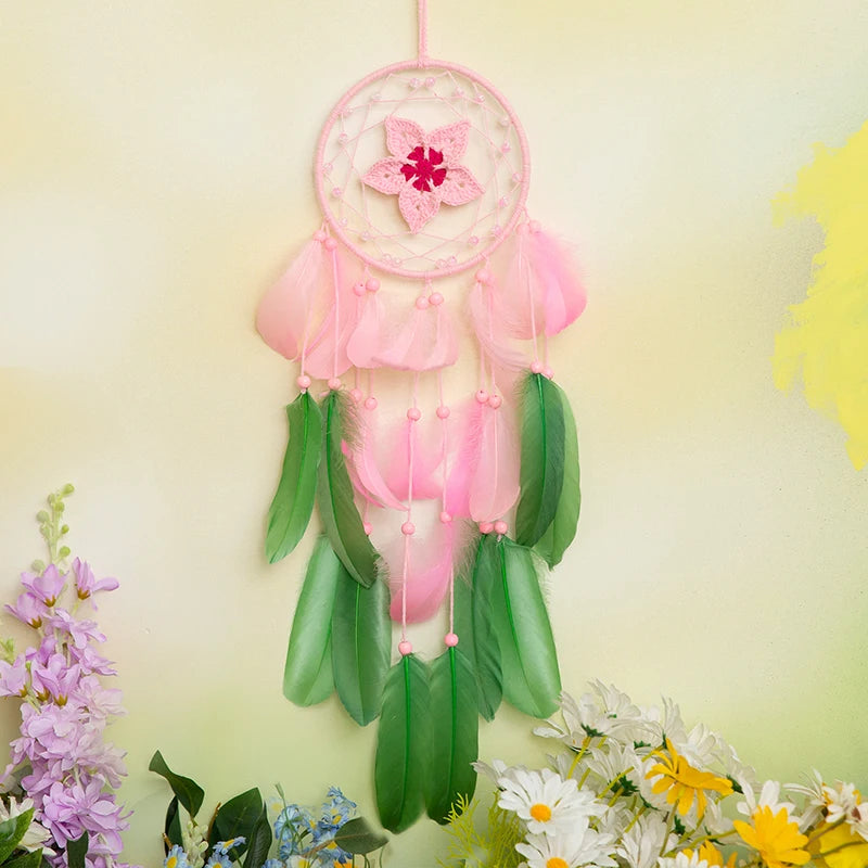 Une magnifique suspension florale rose et verte avec des plumes suspendues dans un cercle de rêve.