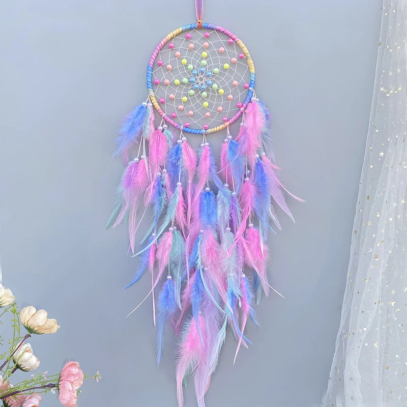 Le capteur de rêves multicolore orné de plumes roses, bleues et jaunes crée une atmosphère magique et apaisante.