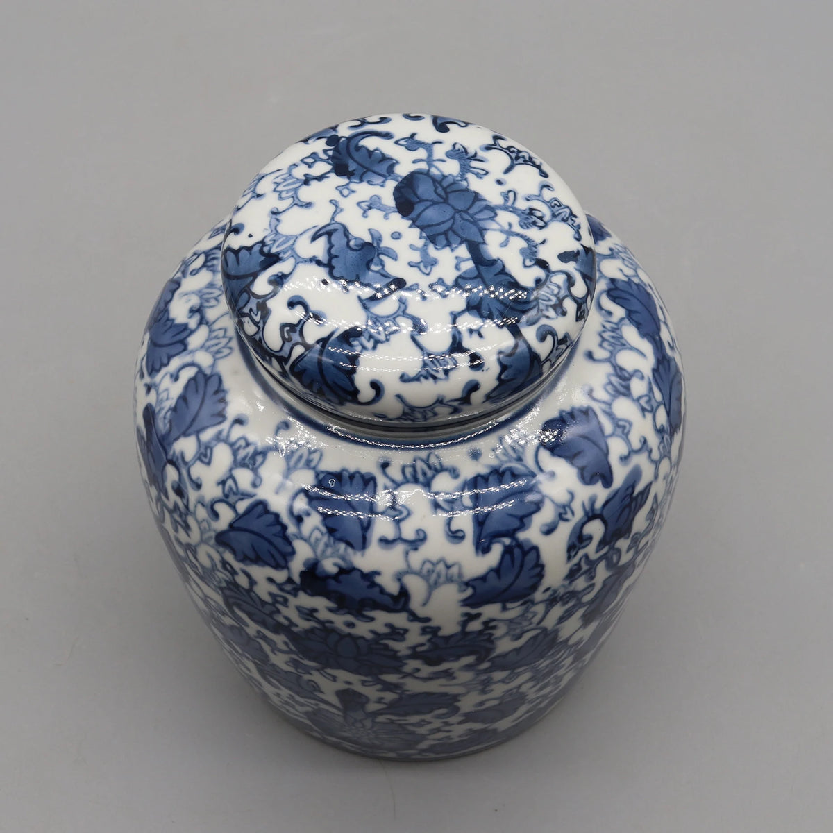 Vase décoratif en porcelaine blanche et bleu, présentant un motif floral délicat et élégant.