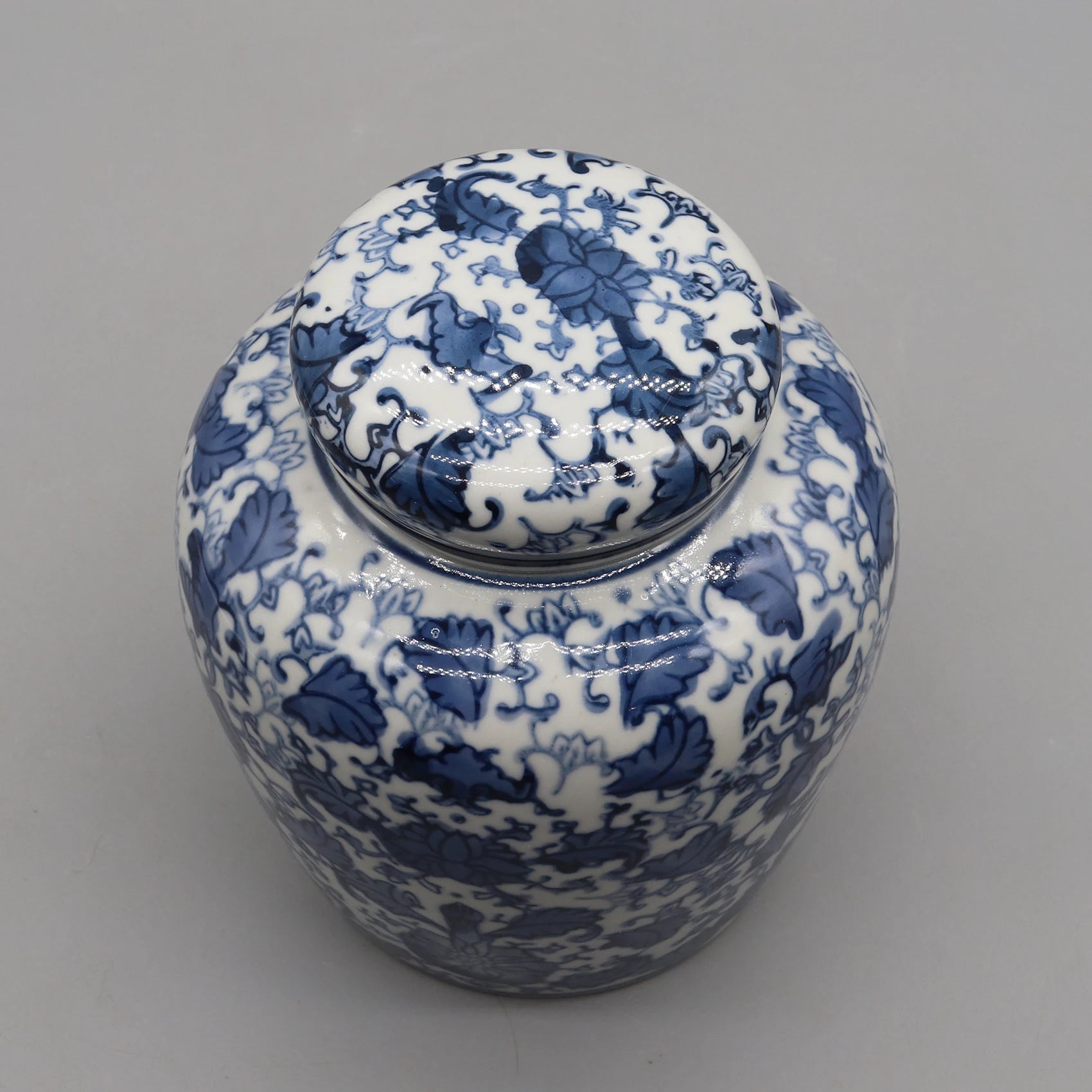 Vase décoratif en porcelaine blanche et bleu, présentant un motif floral délicat et élégant.