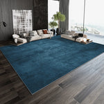 Une pièce élégante et moderne avec un canapé confortable et des éléments décoratifs soignés, sur un tapis bleu profond contrastant avec le parquet en bois.